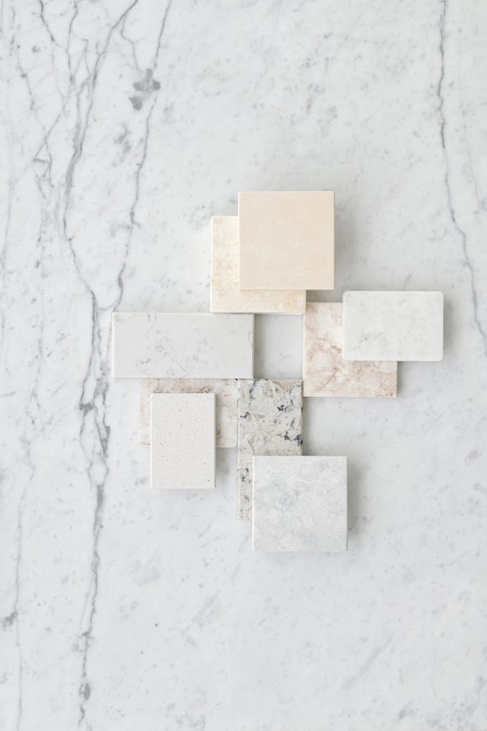 about-us Aesthetic flat lay of various marble tiles arranged on a textured marble surface.