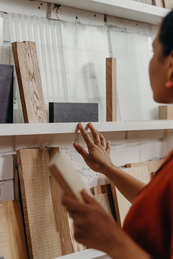 Close-up of woman choosing wood samples for interior design project.